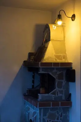 a brick fireplace with a light on top of it at Къща за гости В 12 и 5 in Dolna Banya