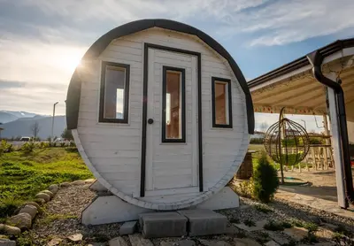 a tiny house sitting outside of a house at Къща за гости В 12 и 5 in Dolna Banya