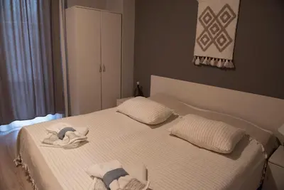 a bedroom with a white bed with towels on it at Къща за гости В 12 и 5 in Dolna Banya