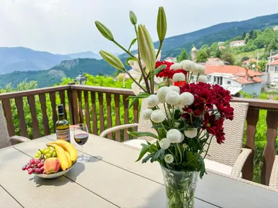 a vase of flowers and a bowl of fruit on a table at Каменната къща in Borowo