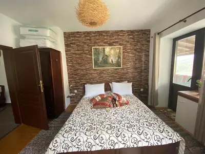 a bedroom with a bed with a brick wall at Каменната къща in Borowo