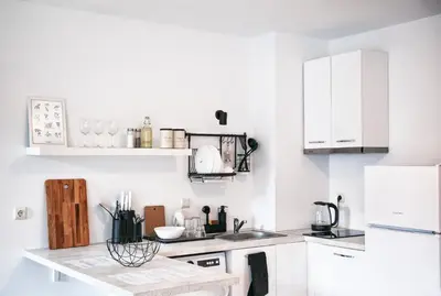 a kitchen with white cabinets and a counter top at New White Studio F next to Forest the Gondola in Bansko