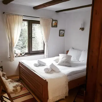a bedroom with a bed with two towels on it at Майоровата къща in Shiroka Lŭka