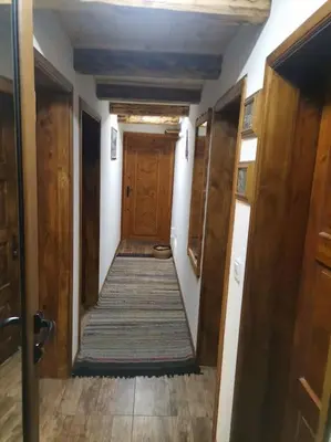 a hallway with a wooden door in a house at Майоровата къща in Shiroka Lŭka