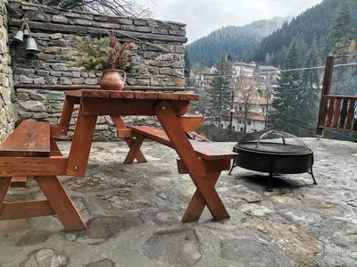 a picnic table and a grill on a patio at Майоровата къща in Shiroka Lŭka