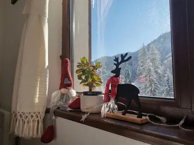 a window sill with santa claus figurines and a reindeer on at Майоровата къща in Shiroka Lŭka