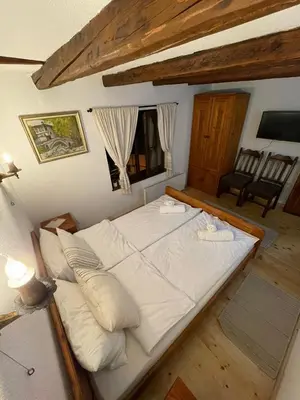 a large bed with white pillows in a room at Майоровата къща in Shiroka Lŭka