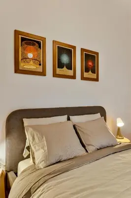 a bed with three pictures on the wall above it at Dreamy Sunset Loft in Sofia City Center in Sofia
