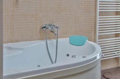 a bathroom with a tub with a blue container on it at Sofia center best view by Flat Mаnager in Sofia