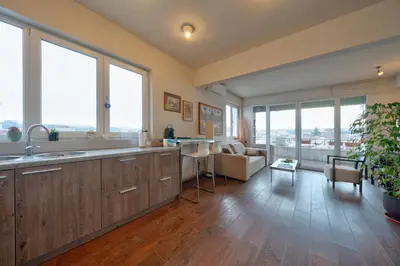 a large kitchen with wooden floors and large windows at Sofia center best view by Flat Mаnager in Sofia