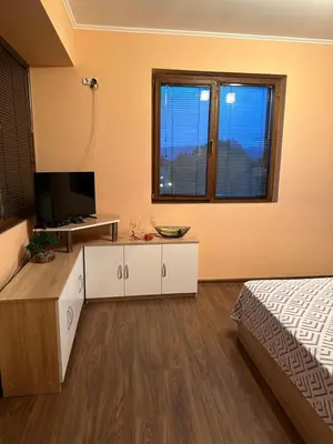 a bedroom with a bed and a tv and a bed at Къща за гости Арнаудови in Kostandovo