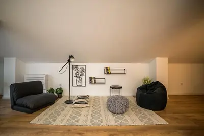 a living room with a couch and a chair at ARHEYA 8 apart/АРХЕЯ 8 апартамент за гости in Karlovo
