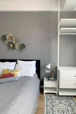 a bedroom with a white bed and a white night stand at Elegant Getaway Near Iconic Eagles' Bridge in Sofia