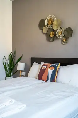 a bedroom with a white bed with flowers on the wall at Elegant Getaway Near Iconic Eagles' Bridge in Sofia