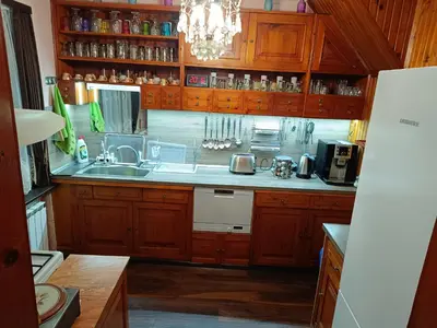 a kitchen with wooden cabinets and a sink at Detached Guest House Рилски кът Маджаре in Madzhare