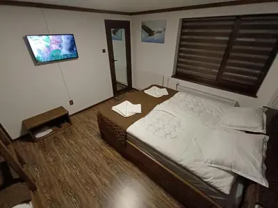 a bedroom with a large bed and a window at Detached Guest House Рилски кът Маджаре in Madzhare
