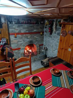 a table with a fireplace in a room at Detached Guest House Рилски кът Маджаре in Madzhare