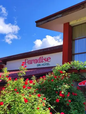 a sign on the side of a building with red flowers at Paradise SPA Hotel in Tsigov Chark