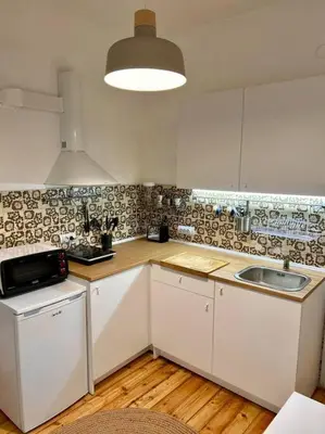 a kitchen with white cabinets and a sink at Chic Urban Retreat in Sofia