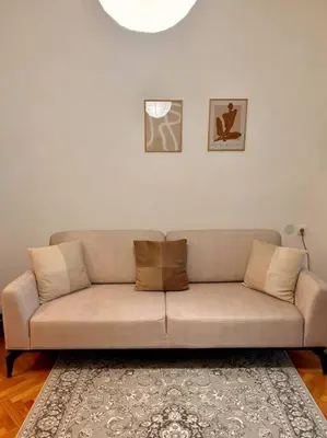 a tan couch in a living room with a rug at Chic Urban Retreat in Sofia