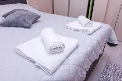 a white bed with towels and pillows on it at Apartment Betty in Sandanski