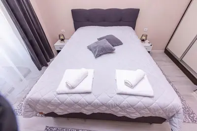 a bedroom with a large bed with two pillows at Apartment Betty in Sandanski