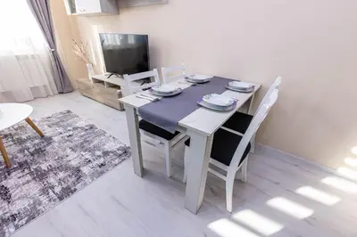 a dining room with a table and chairs and a television at Apartment Betty in Sandanski