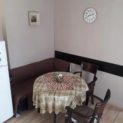 a table and chairs in a room with a clock on the wall at Studio V Plovdiv in Plovdiv