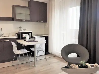a kitchen with a table and chairs in a room at Sky Apartments in Blagoevgrad
