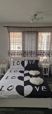 a bedroom with a bed with a black and white bedspread at Black and White Apartment in Karlovo