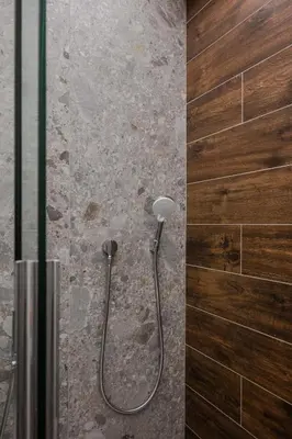 a shower in a bathroom with a wooden wall at SOFapart Boutique Apartments in Sofia