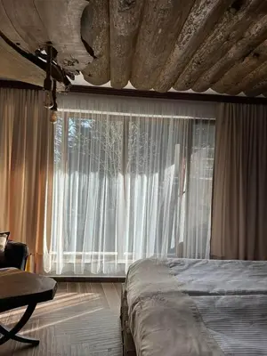 a bedroom with a bed and a large window at CHALET ELEVEN in Dospat