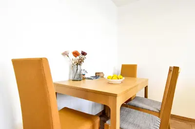 a wooden table with a bowl of fruit and a vase of flowers at Doynov's Apartment in Sofia