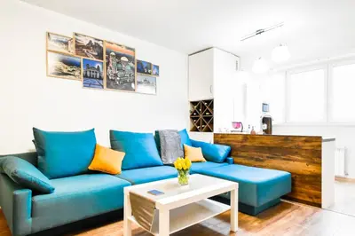 a living room with a blue couch and a table at Doynov's Apartment in Sofia