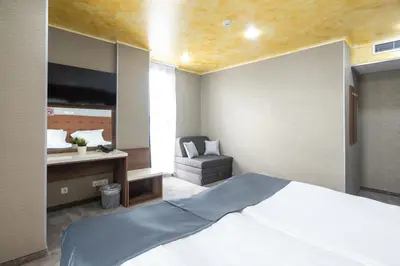 a bedroom with a large white bed and a desk at Hotel Boutique 5 - Free parking - Free breakfast - Free internet - EVSE in Sofia
