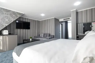 a bedroom with a large white bed and a couch at Hotel Boutique 5 - Free parking - Free breakfast - Free internet - EVSE in Sofia