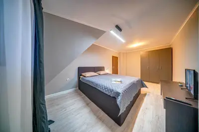 a bedroom with a bed in the corner of a room at Dream View Apartments in Pamporovo