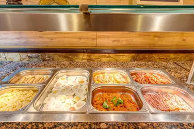 a buffet line with trays of different types of food at Dream View Apartments in Pamporovo