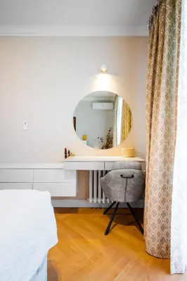 a bathroom with a vanity with a mirror and a chair at Cozy Heaven at Vitosha Blvd - Sofia - 2BDR in Sofia