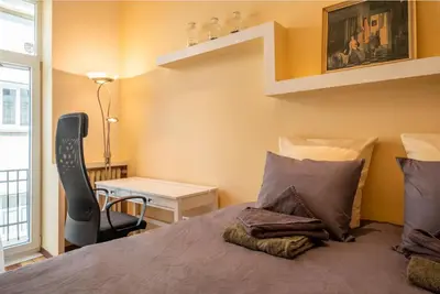 a bedroom with a bed with a chair and a desk at Charming 2BDR Apartment in Historic Center With Parking in Sofia