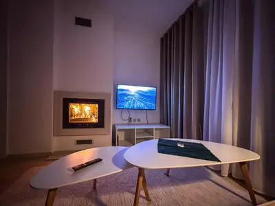 a living room with a coffee table and a tv at Bansko Ski Resort Apartment 2-3 people in Bansko