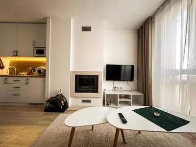 a living room with a white couch and a table at Bansko Ski Resort Apartment 2-3 people in Bansko