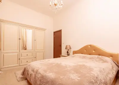 a white bedroom with a bed and a chandelier at The Golden Nest - 3 Bedroom Family Mountain Apartment in Pamporovo