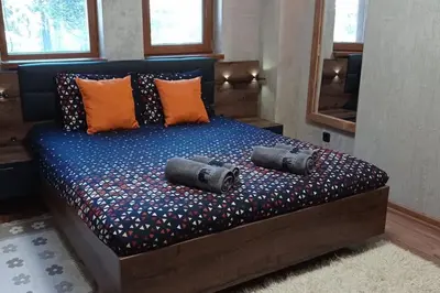a bedroom with a bed with two speakers on it at АПАРТАМЕНТ WISH in Pamporovo