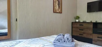 a bed with a pair of towels and a dresser at АПАРТАМЕНТ WISH in Pamporovo