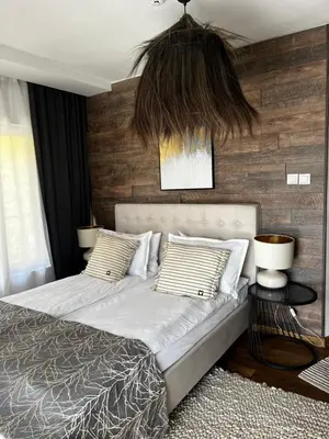 a bedroom with two beds and a hanging pendant at Valmont Luxury Chalet in Glozhene