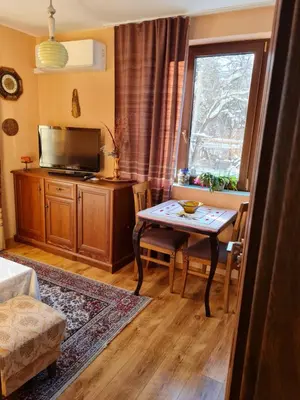 a living room with a table and a window at Cozy apartment with balcony in Sofia