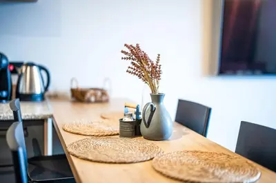 a wooden table with plates and a vase on it at Bansko Best View Apartment in Bansko