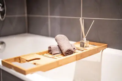 a wooden tray with two towels sitting on a bath tub at Bansko Best View Apartment in Bansko