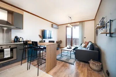 a kitchen and living room with a couch and a table at Bansko Best View Apartment in Bansko